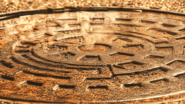 Wet manhole cover on hot street