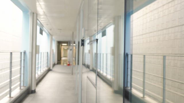 Woman walking down a bright hallway