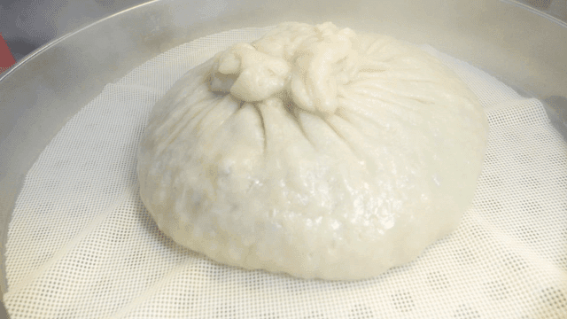 Large dumplings being steamed in steamer