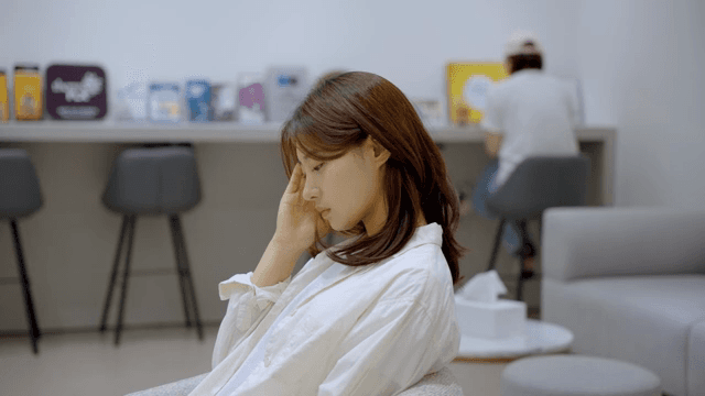 실내에서 두통을 앓고 있는 여성