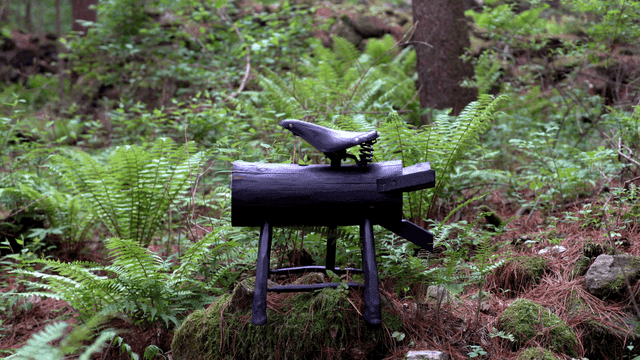 Wooden log with a bicycle seat in the forest