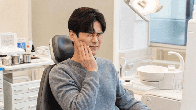 Male patient suffering from toothache at dental clinic