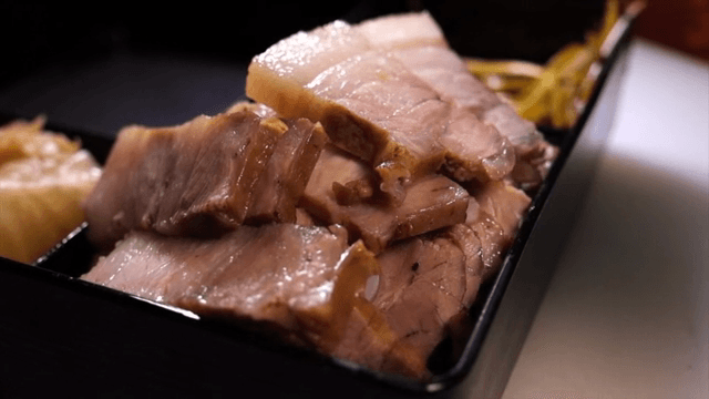 검은 쟁반에 담긴 돼지고기 수육