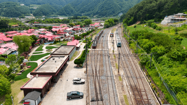 Village with red roofs and passing train
