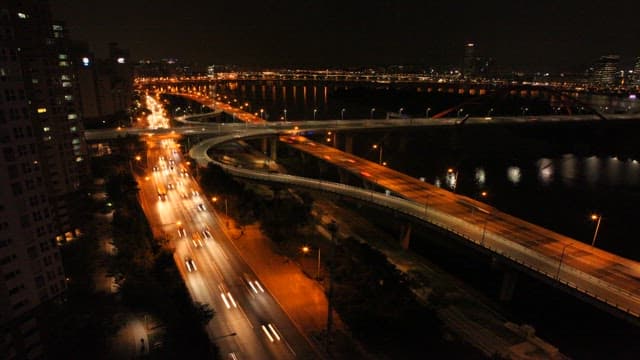 Night View of the City and Bridge Illuminated by Car Lights