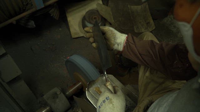 작업장에서 칼을 갈고 있는 작업자