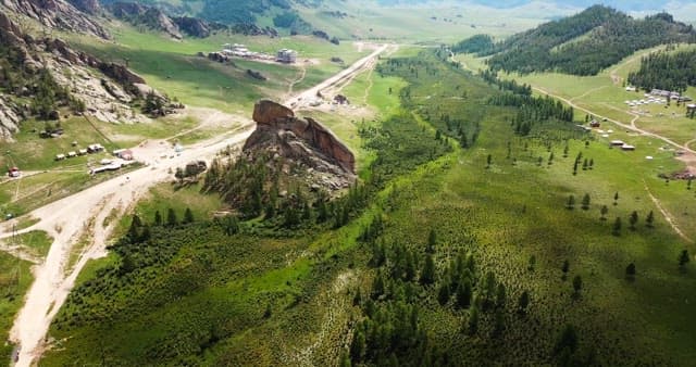 Vast green landscape with rocky hills