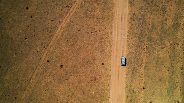 Single car driving on a remote desert road