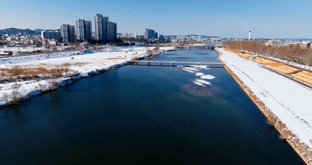 Snow-covered river and city skyline