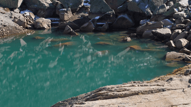 Lake beneath snow-covered rocks