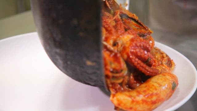 Spicy braised seafood with octopus and abalone being served