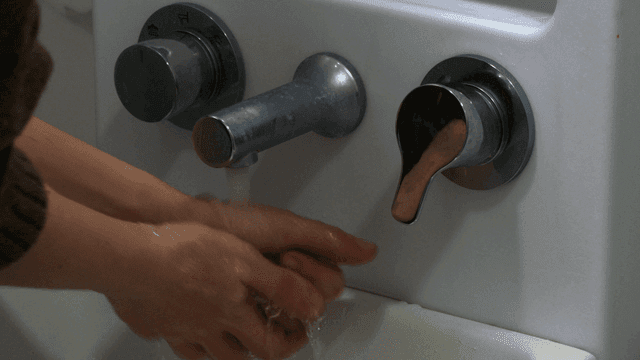Person washing his hands under faucet