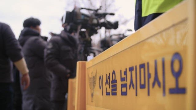 경찰의 폴리스 라인 앞에 선 촬영기사들
