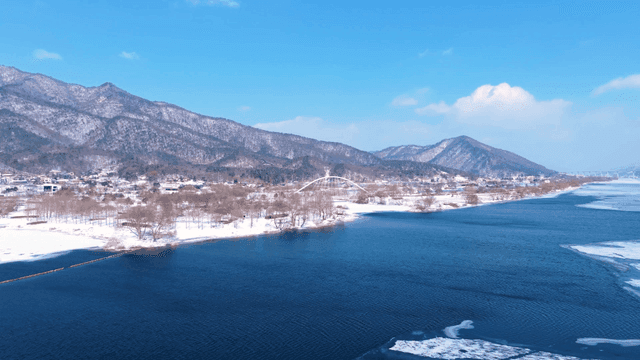 산을 배경으로 한 눈 덮인 강변
