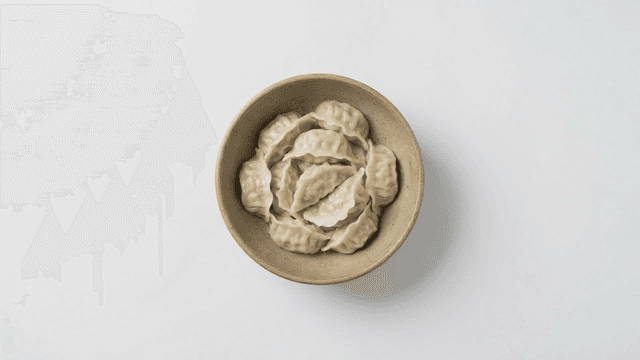 Bowl of steamed dumplings on white background