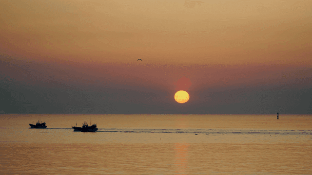 Fishing boats at sunrise on the calm sea
