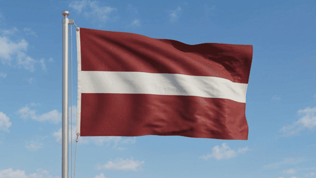 Latvian flag fluttering against clear sky