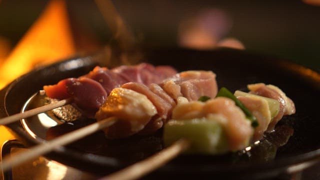 밤에 가스 버너 위 팬에서 조리되는 꼬치