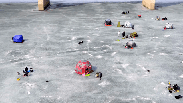 People ice fishing on a frozen lake