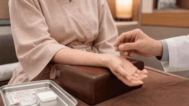 Korean medicine doctor administering acupuncture to patient's wrist