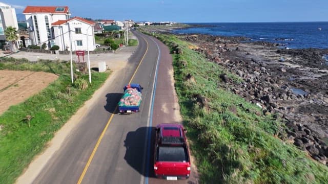 Coastal road with cars and ocean scenery on a clear sunny day