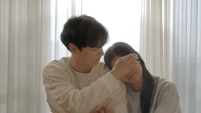 Couple resting by cozy window with gentle lean