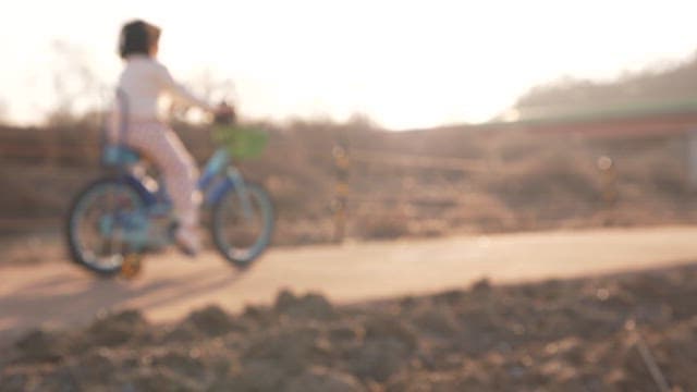 Child Riding Bicycle Outdoors on a Sunny Day