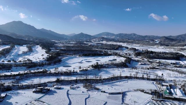 Snowy Landscape with Golf Course and Mountains