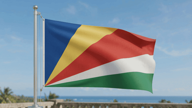 Flag of Republic of Seychelles waving against backdrop of sea