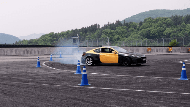 Car drifting on a track with cones
