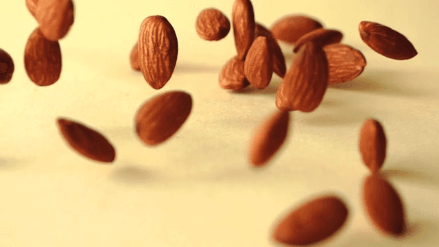 노란색 바닥에 떨러지는 아몬드