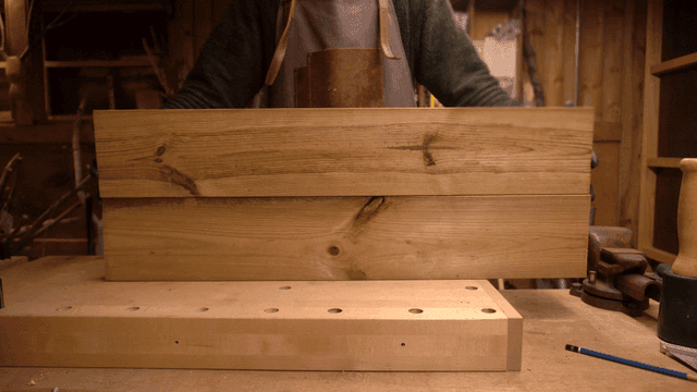 목공 작업장에서 나무 판자를 정리하는 목수