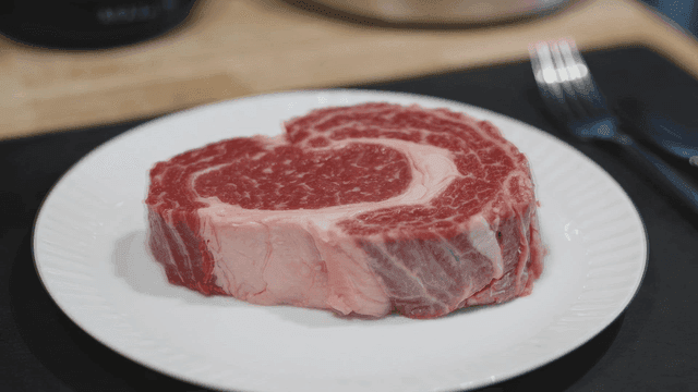 Raw steak on white plate