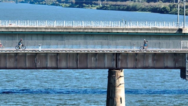 Cyclists riding on a bridge over a river