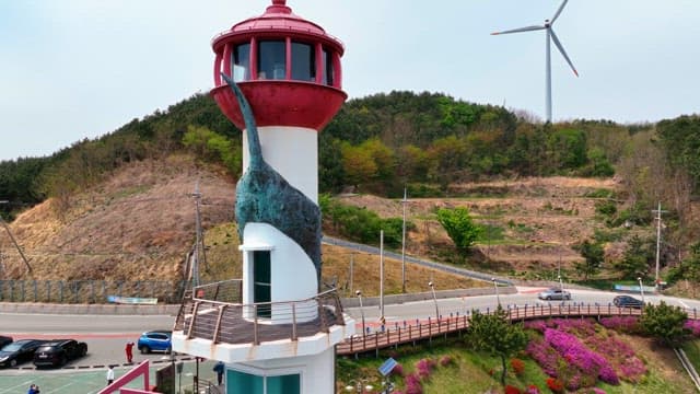 해안 언덕의 등대와 풍력 터빈