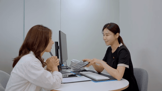 상담실에서 계산기를 두드리며 견적 상담을 진행하는 모습
