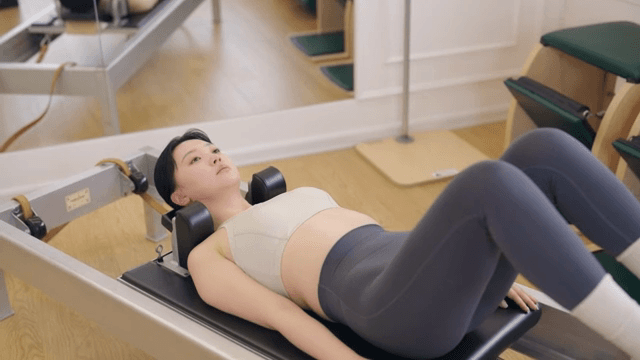 Woman exercising on a pilates reformer