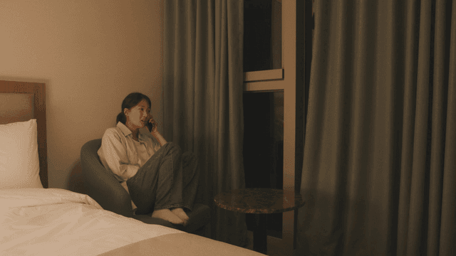Woman sitting in a room talking on phone
