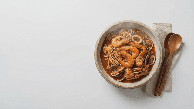 Bowl of spicy seafood stew with shrimp and clams