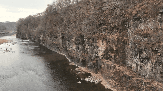 Serene river flowing beside rocky cliffs