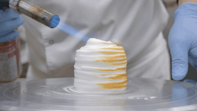Chef using a blowtorch on a dessert