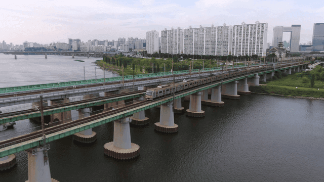Train crossing bridge in city landscape