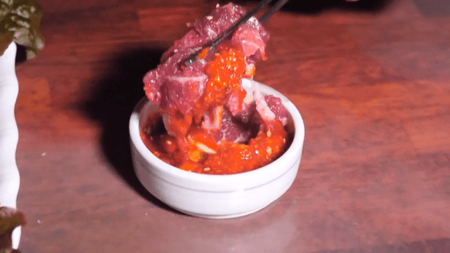 생고기를 매운 소스에 찍는 장면