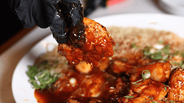 Glovenly hand lifting spicy braised chicken meat