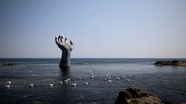 Large hand sculpture in the ocean