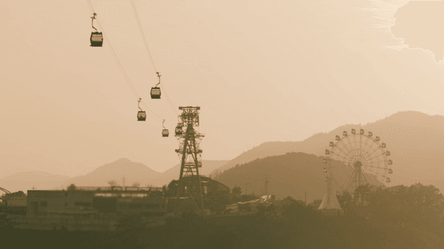 Cable cars and ferris wheel at sunset