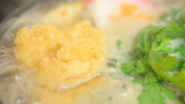 Warm udon noodles soup with fish cake and vegetables