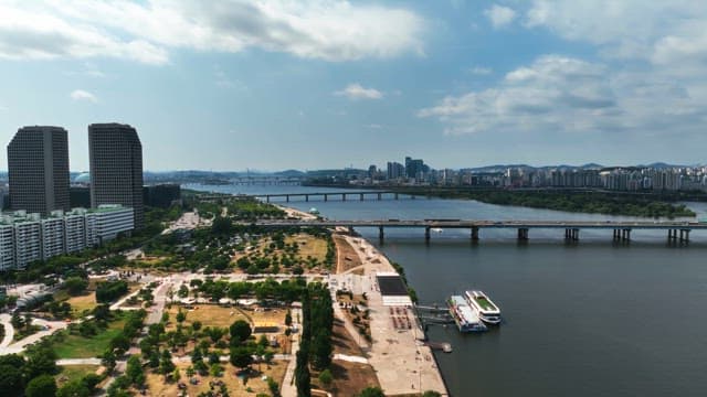 Riverside cityscape with scenic park and bridge