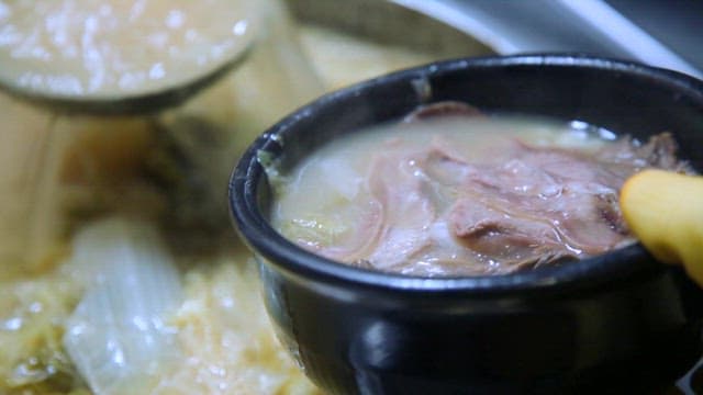 해장국을 그릇에 담는 장면