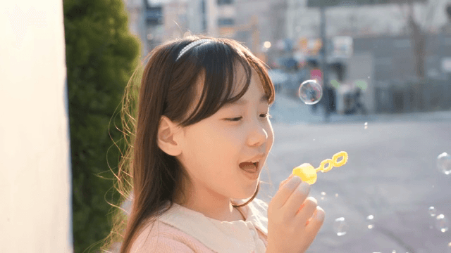 Child blowing bubbles outdoors